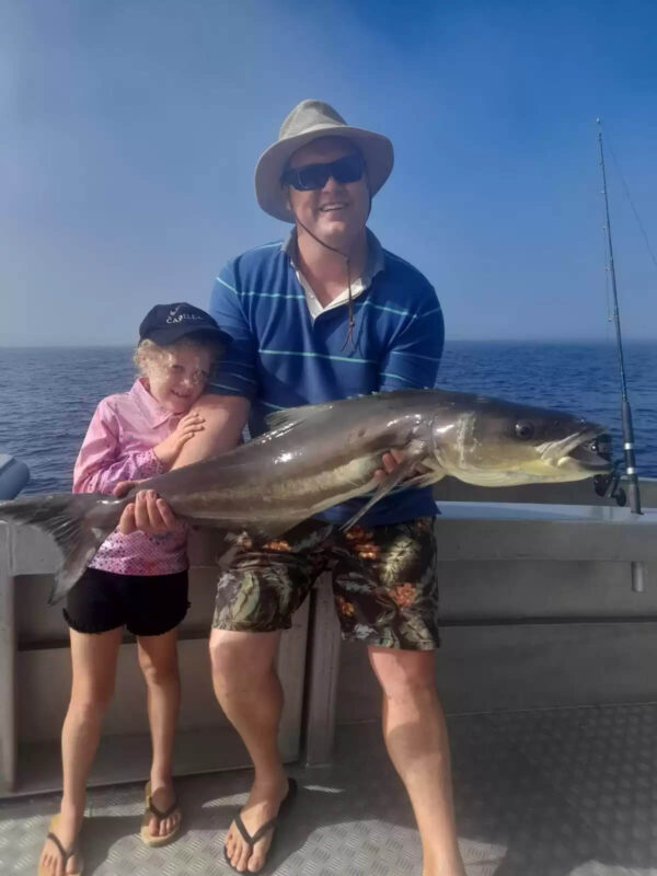 Father and daughter holding a fish caught on a Broome fishing charter