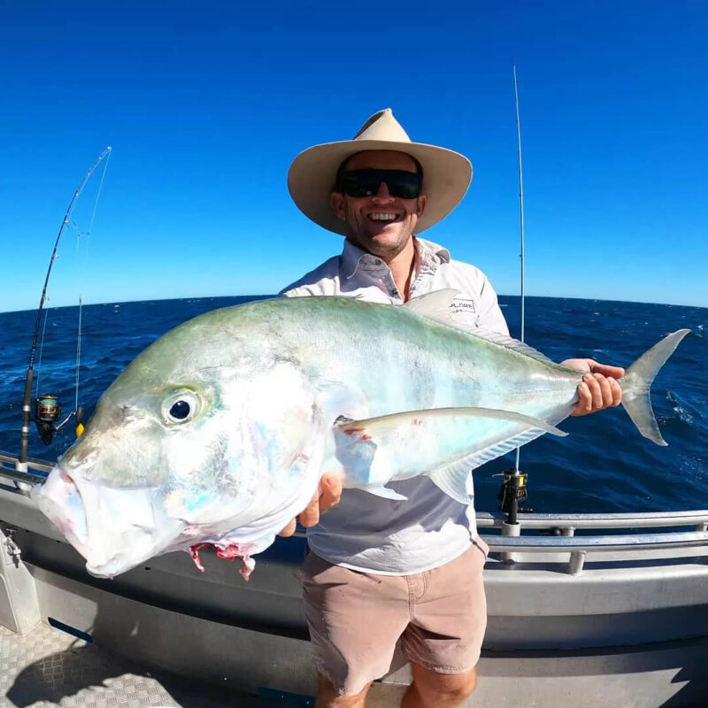Man holding a fish just caught on Broome fishing charter