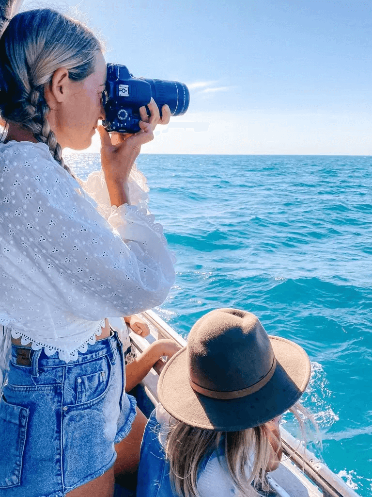 Woman taking photos of ocean in Broome