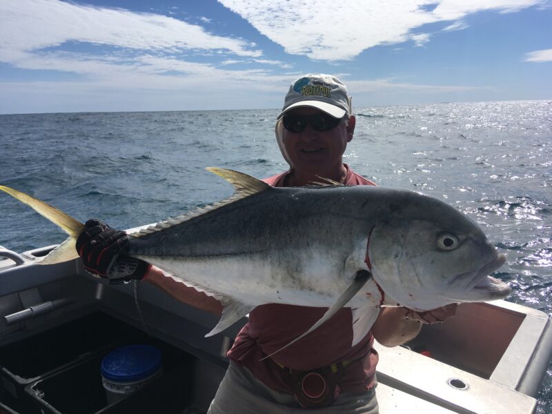 Fisherman holding GT fish on Broome fishing charter